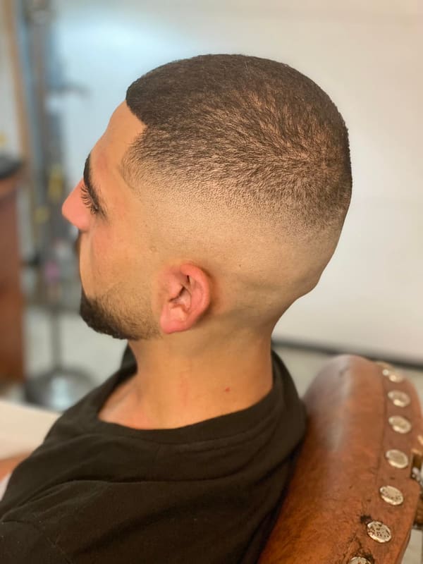 Side view of a high skin fade with a short textured top
